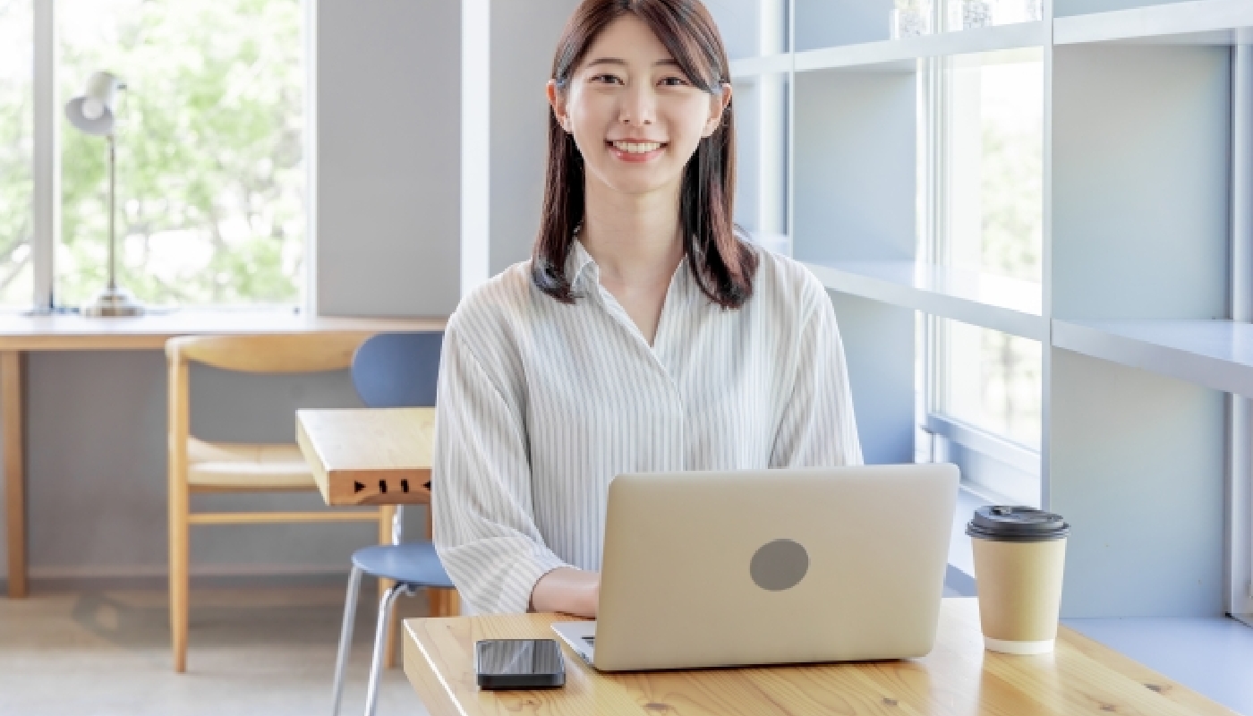 PCの前で笑顔の女性