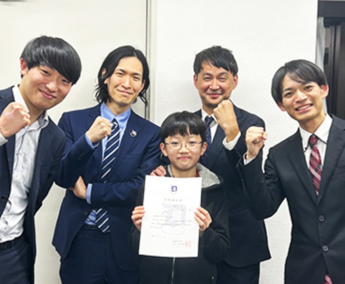 合格を祝い先生達と写真を撮る生徒