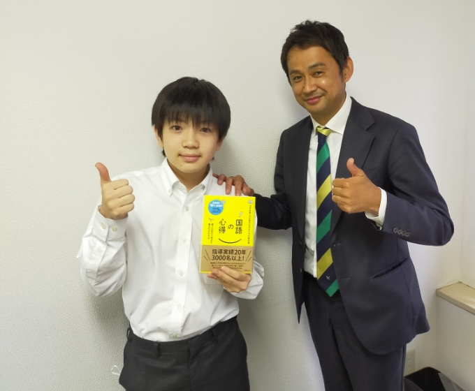 書籍を持った子どもと先生の写真