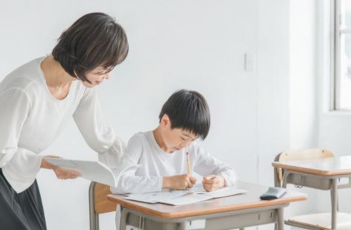 先生に算数の指導を受ける子ども