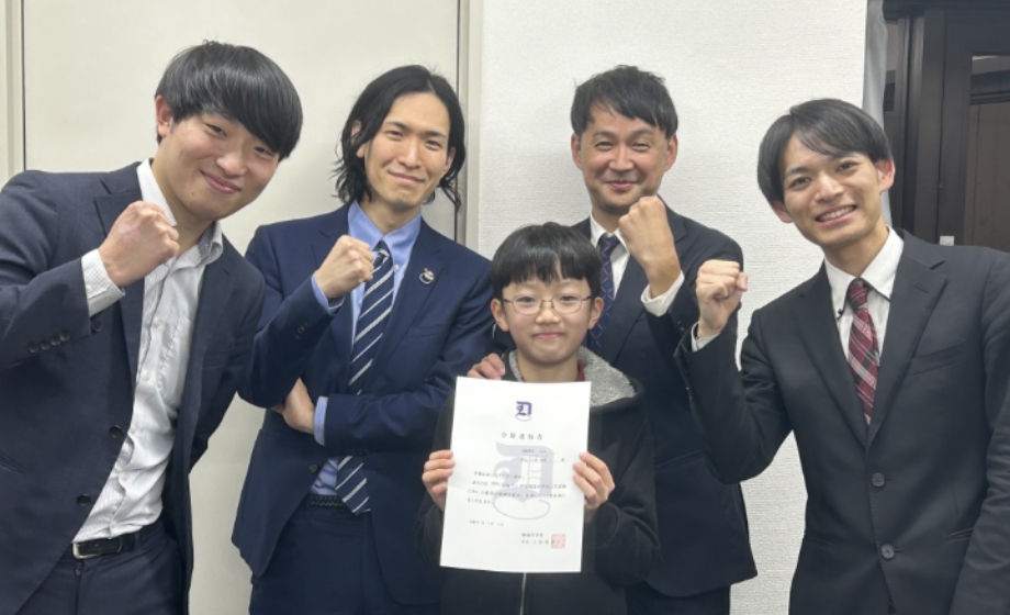 合格を祝い先生達と写真を撮る生徒