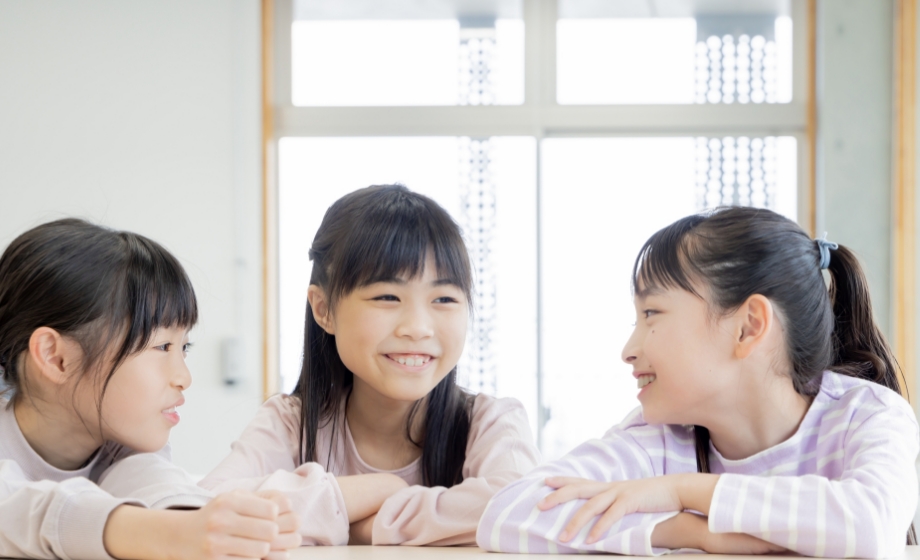 笑顔で話す３人の子ども